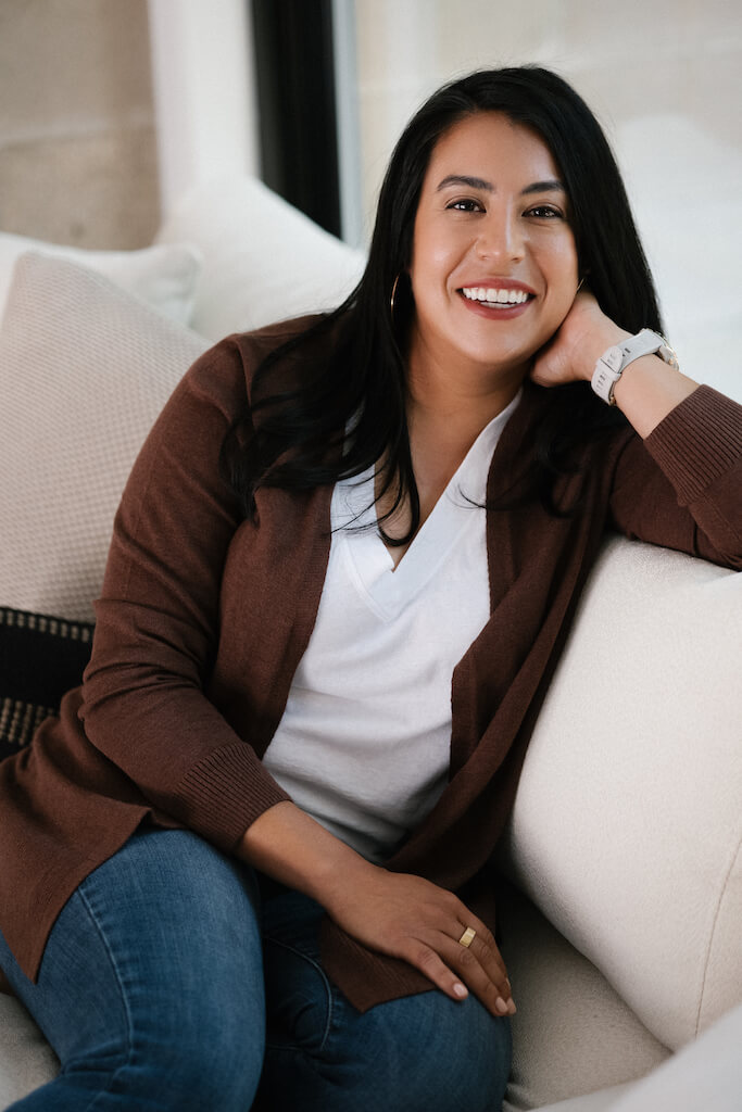 google ads specialist olivia lawson sitting on a couch dressed casually and smiling