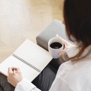 woman taking notes on google ads conversion tracking while drinking coffee