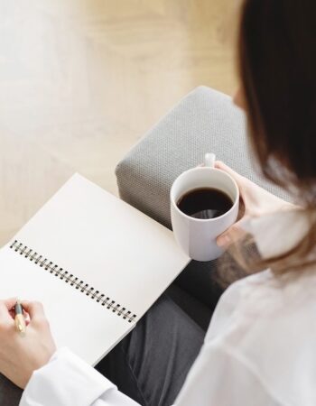 woman taking notes on google ads conversion tracking while drinking coffee